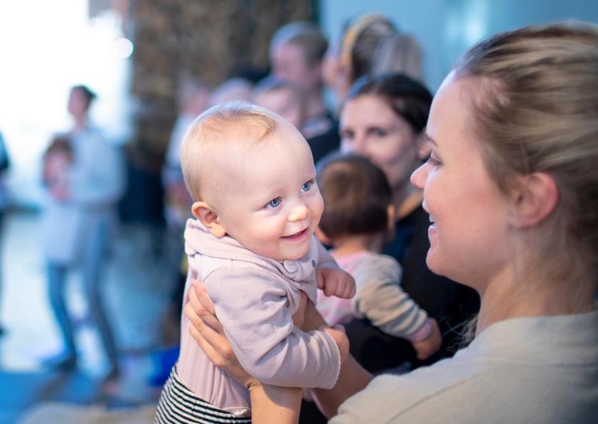 Baby løftet over skulder på mamma